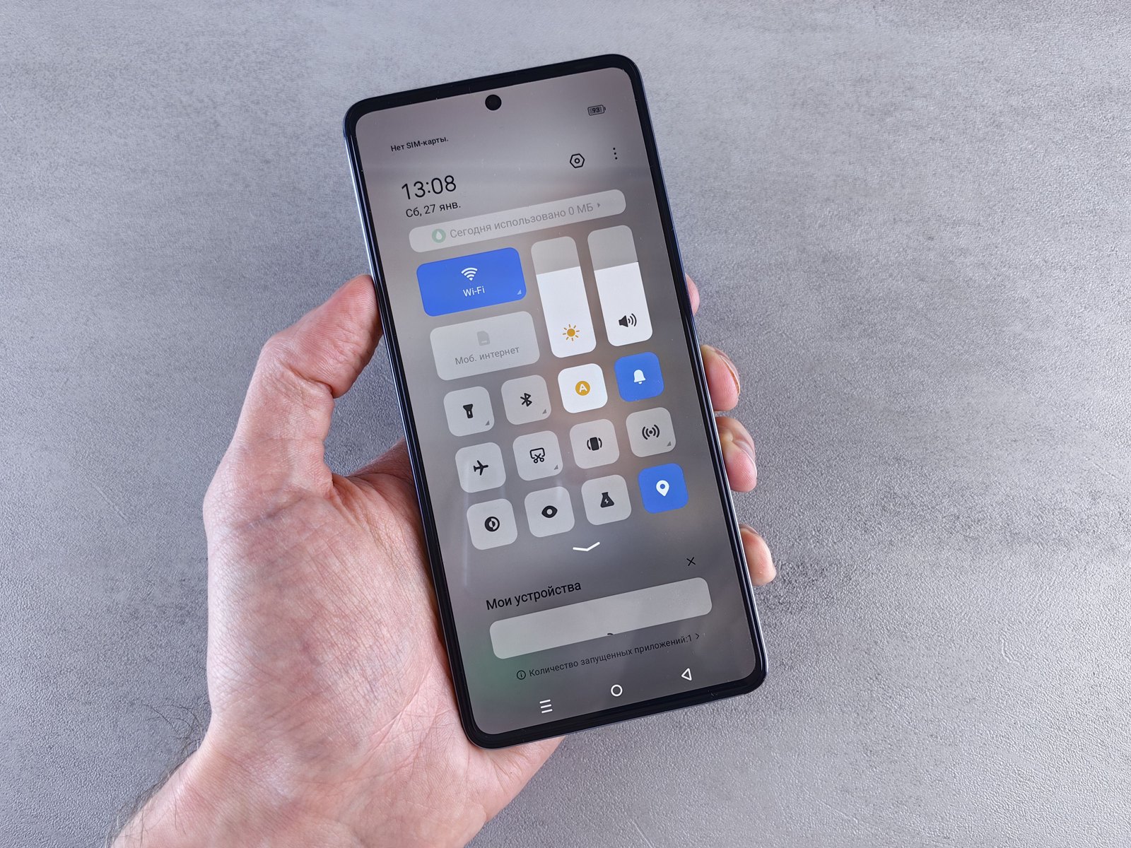 Illustrative photo of a hand holding an Android phone with its settings panel open; not a Nothing Phone or Nothing OS screen.