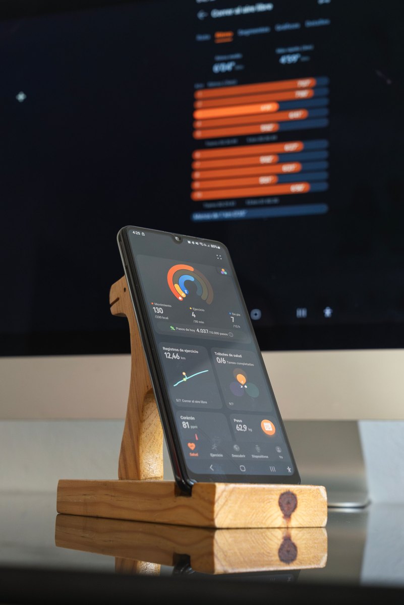 Smartphone displaying a generic health dashboard beside a computer screen