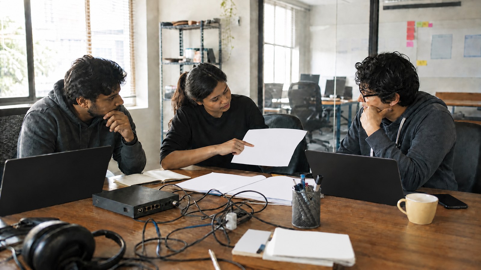 Startup engineering team reviewing an infrastructure sketch in a modest office