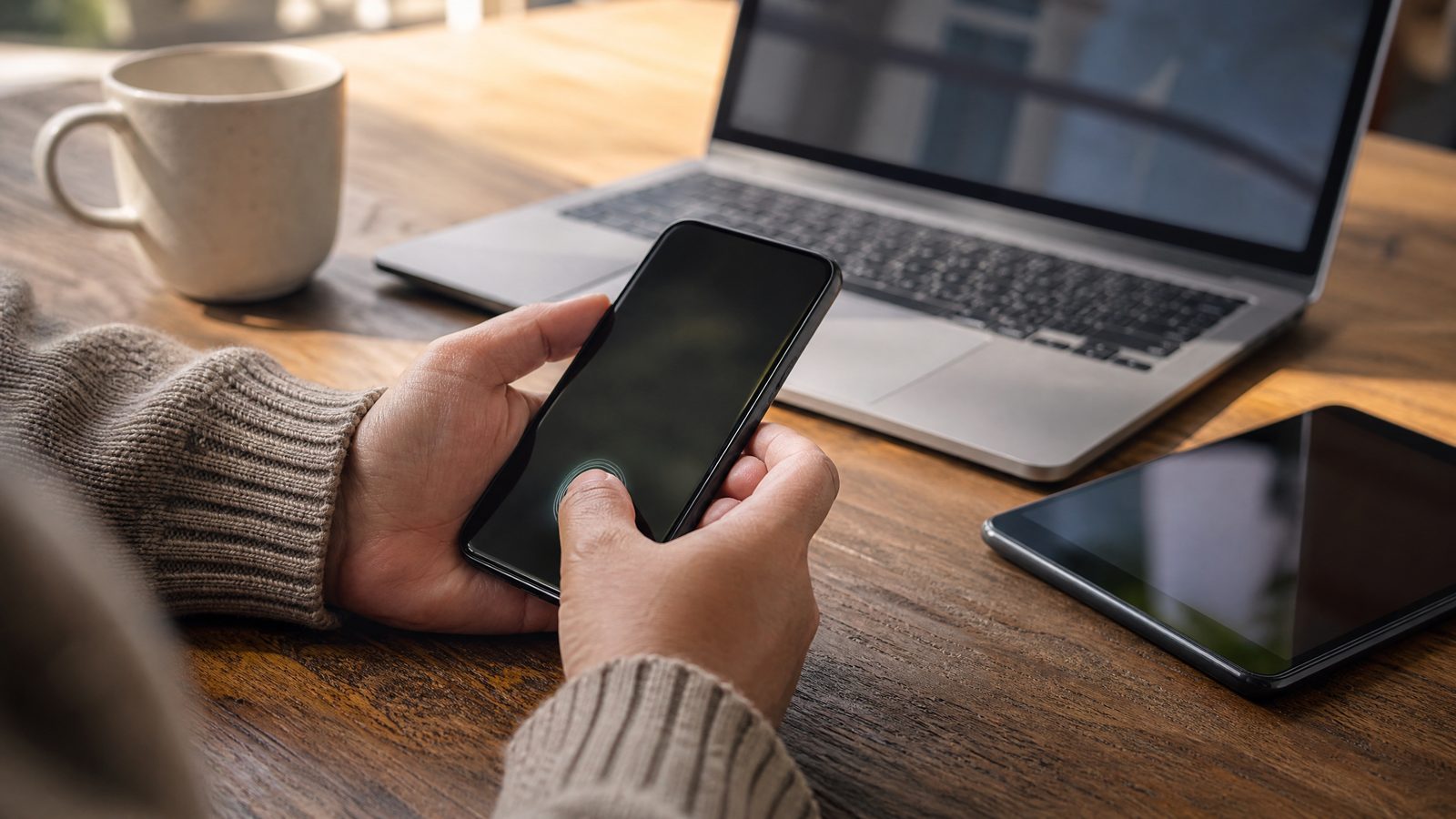 Person authenticating with a passkey on a smartphone beside trusted personal devices