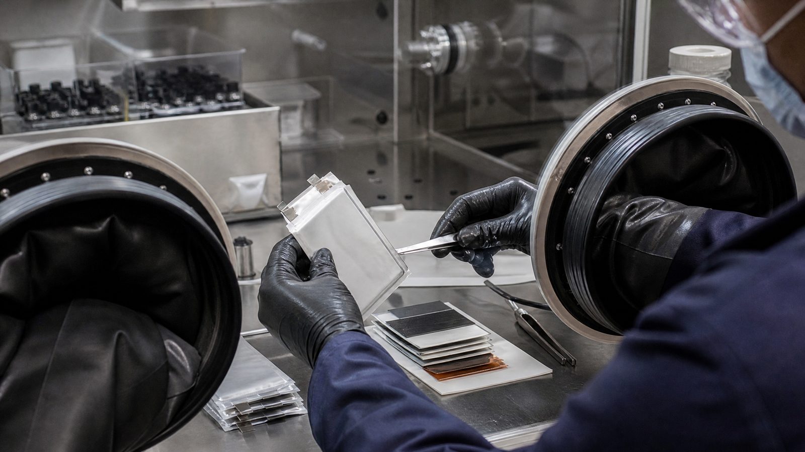 Battery researcher assembling a solid-state pouch cell inside a laboratory glovebox