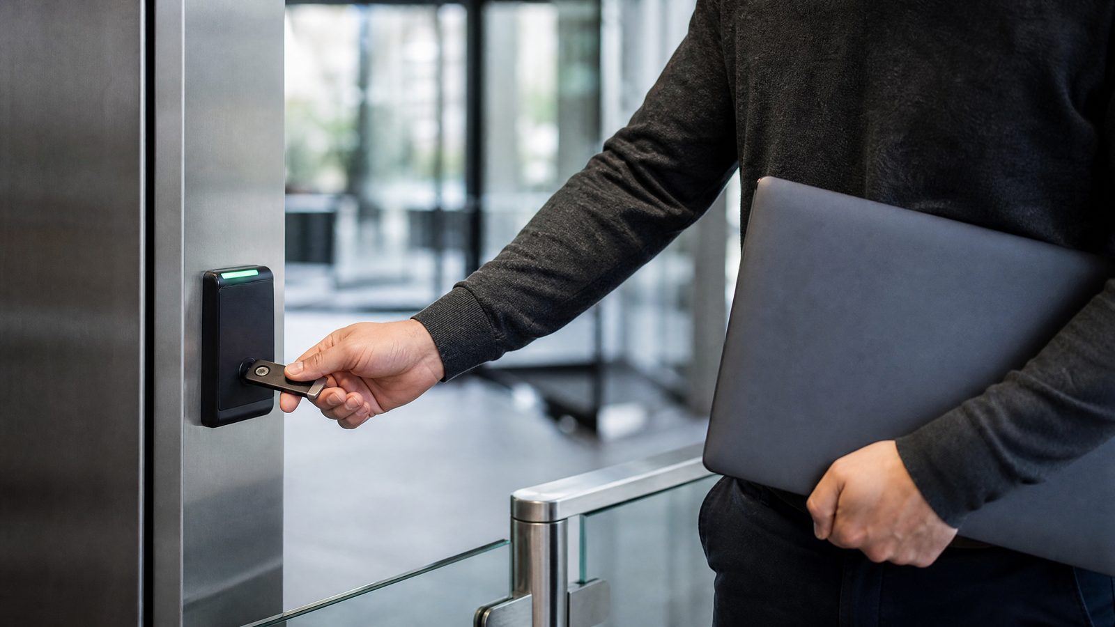 Employee using a physical security key at an office access checkpoint